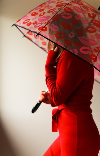 身穿红色长袖衬衫、手持雨伞的妇女